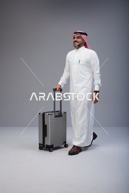 Saudi Man in Traditional Thobe Walking with Suitcase