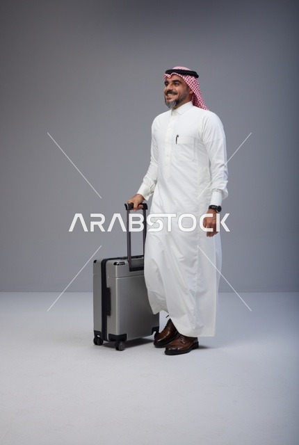 رجل سعودي بالثوب التقليدي مع حقيبة سفر