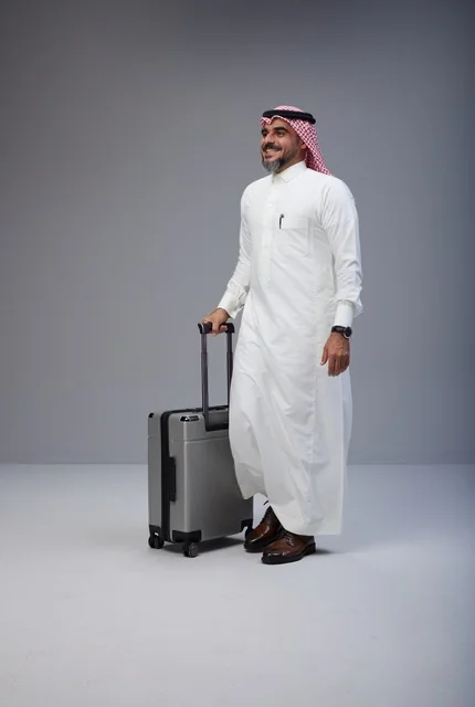 رجل سعودي بالثوب التقليدي مع حقيبة سفر