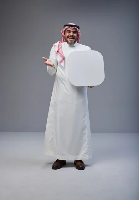 رجل سعودي يرتدي الزي التقليدي يحمل لوحة بيضاء فارغة