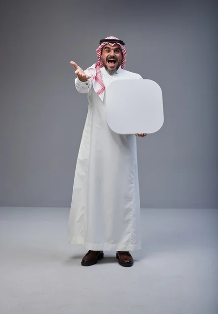 رجل سعودي يحمل لوحة بيضاء فارغة في الاستوديو