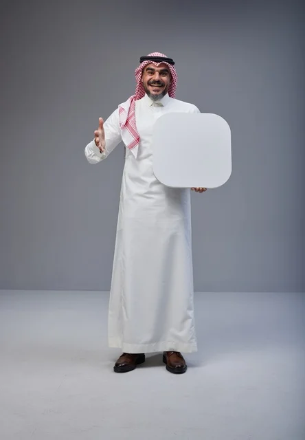 رجل سعودي يرتدي الثوب ويحمل لوحة بيضاء فارغة للإعلان
