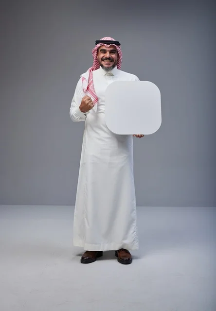 رجل سعودي يحمل لوحة بيضاء فارغة في الاستوديو