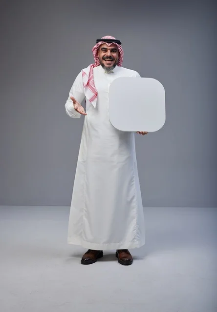 رجل سعودي يحمل لوحة بيضاء فارغة في الاستوديو