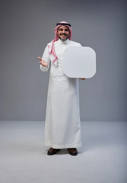 رجل سعودي يحمل لوحة بيضاء فارغة في الاستوديو