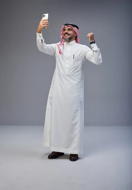 رجل سعودي بالزي التقليدي يلتقط صورة سيلفي