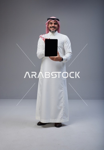 Saudi Man Holding Tablet with Blank Screen in Studio