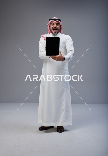 Saudi Man Holding Blank Tablet Screen with Excited Face