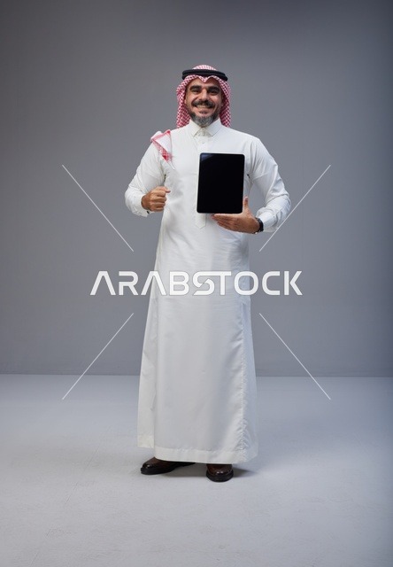 Saudi Man Holding Tablet with Blank Screen in Studio