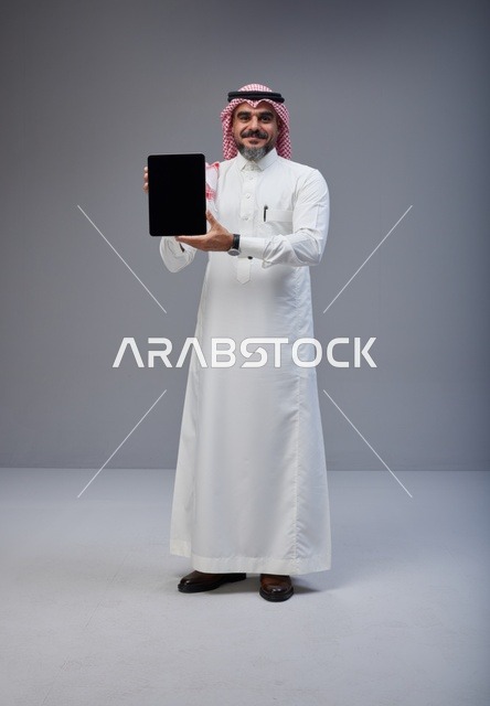 Saudi Man Holding Tablet with Blank Screen in Studio