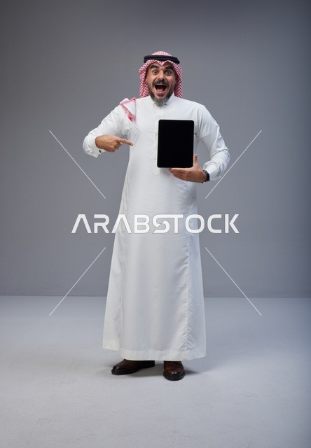 Saudi Man Pointing at Blank Tablet Screen in Studio