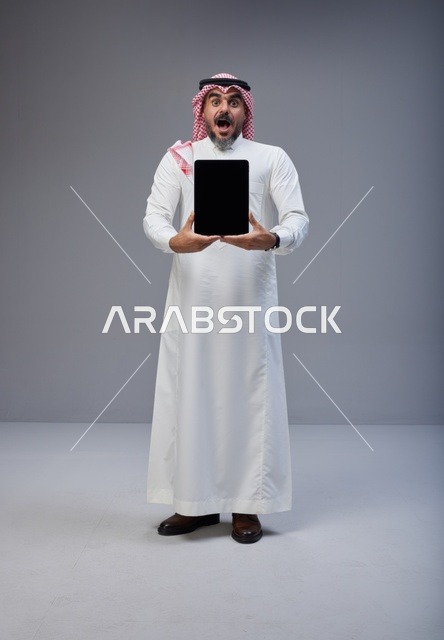 Shocked Saudi Man Holding Blank Tablet Screen