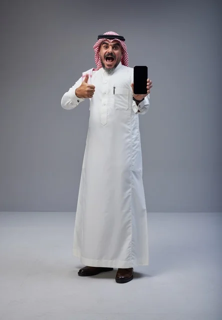 Excited Saudi Man Holding Smartphone with Thumbs Up
