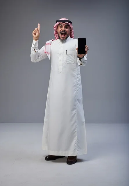 رجل سعودي يحمل هاتف ذكي بشاشة فارغة في الاستوديو