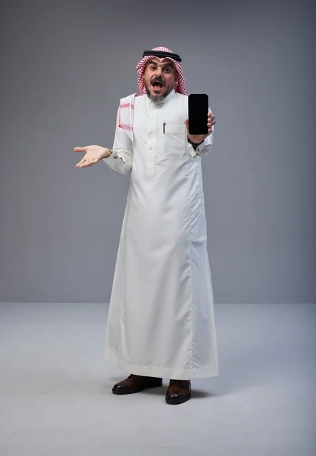 Saudi Man in Traditional Dress Holding Smartphone Screen