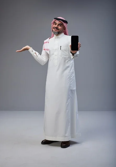 Saudi Man in Traditional Thobe Holding Smartphone