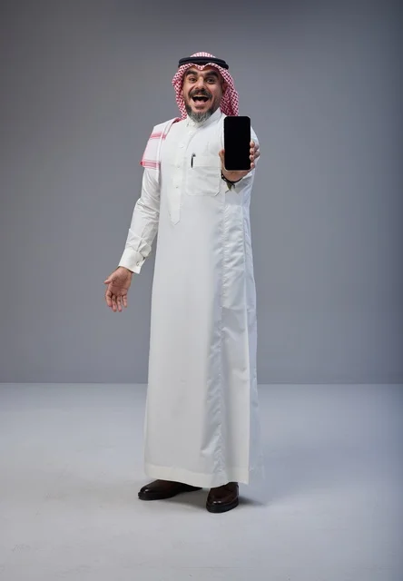 Saudi Man in Traditional Dress Holding Smartphone Screen