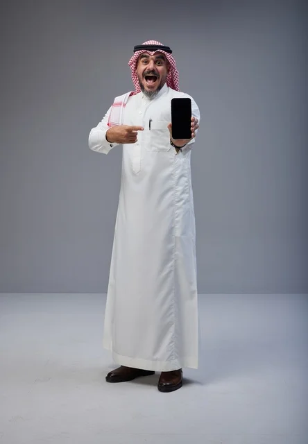 Excited Saudi Man in Traditional Dress with Smartphone