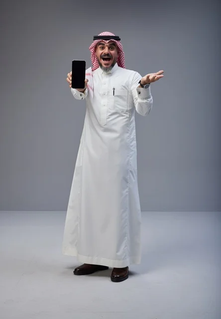 رجل سعودي يحمل هاتف ذكي بتعبير وجه مندهش