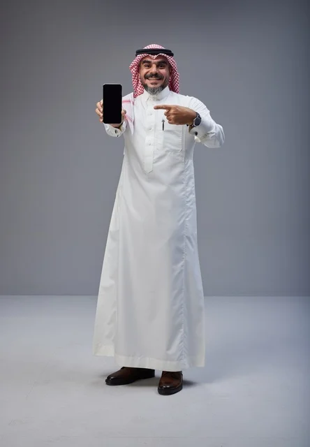 Saudi Man in Traditional Dress Holding Smartphone Studio