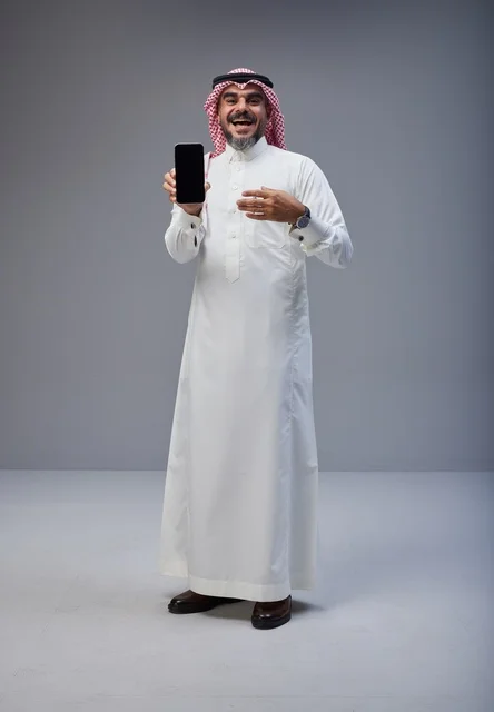 Saudi Man Holding Smartphone with Blank Screen in Studio