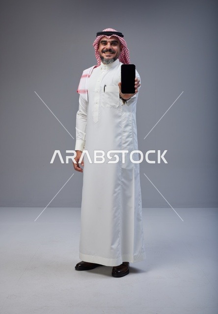 Saudi Man in Traditional Thobe Holding Smartphone