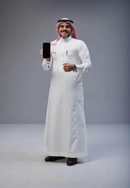 Saudi Man in Traditional Dress Holding Smartphone