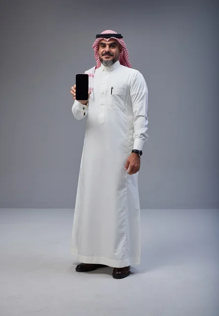 Saudi Man in Traditional Dress Holding Smartphone