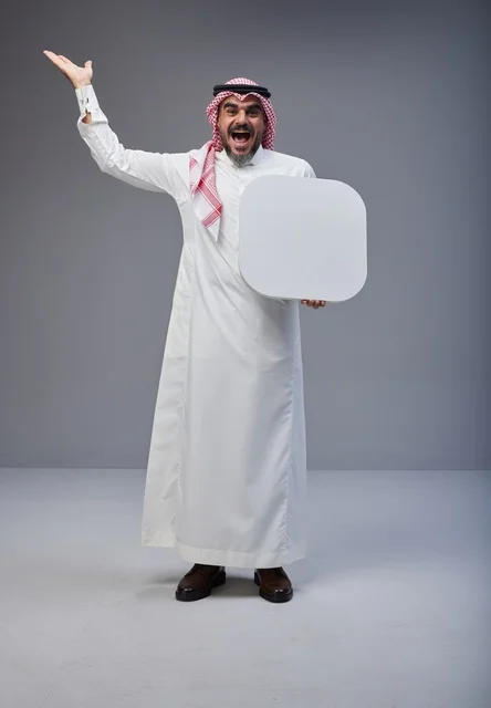 رجل سعودي متحمس يحمل لوحة بيضاء فارغة في استوديو