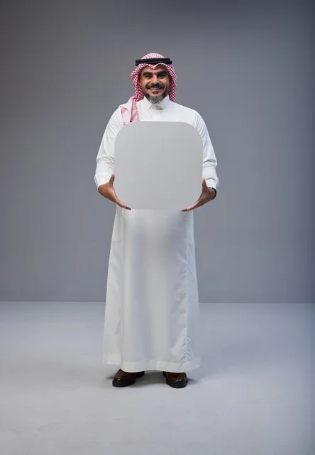 رجل سعودي يحمل لوحة بيضاء فارغة في الاستوديو