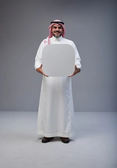 رجل سعودي في الاستوديو يحمل لوحة بيضاء فارغة رجل سعودي في الاستوديو يحمل لوحة بيضاء فارغة