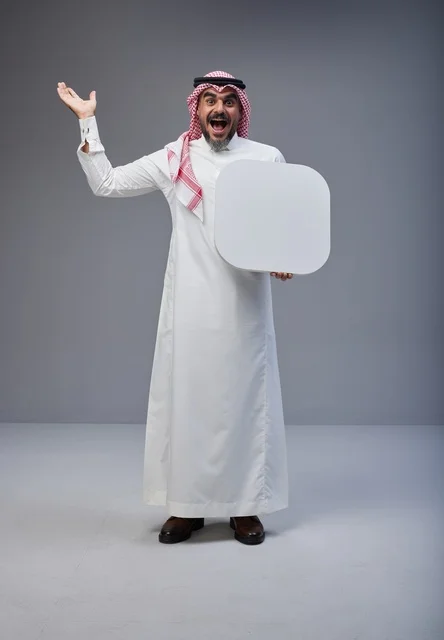 رجل سعودي يحمل لوحة بيضاء فارغة في الاستوديو