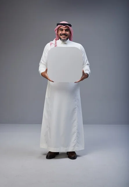 رجل سعودي يحمل لوحة بيضاء فارغة في الاستوديو