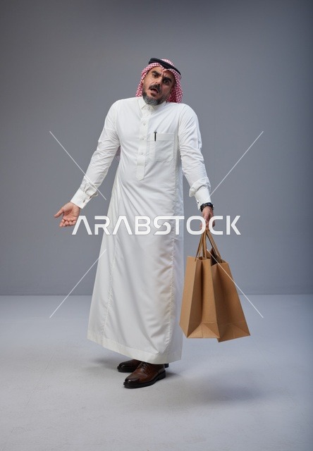 رجل سعودي متعب يحمل أكياس تسوق ورقية
