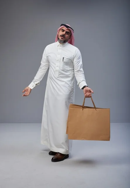 Saudi Man in Traditional Dress with Shopping Bags