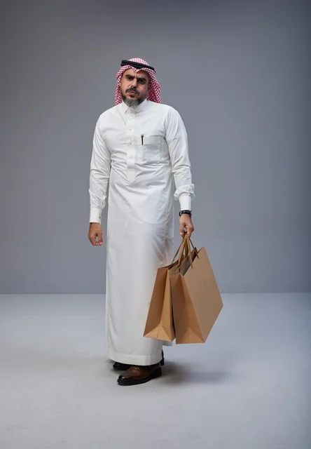 Exhausted Saudi Man Holding Shopping Bags in Studio