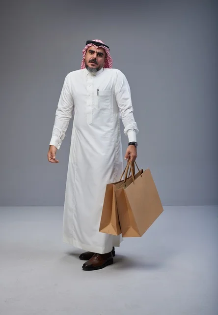 رجل سعودي يحمل أكياس تسوق في الاستوديو