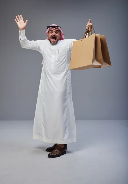 Excited Saudi Man Holding Shopping Bags in Studio