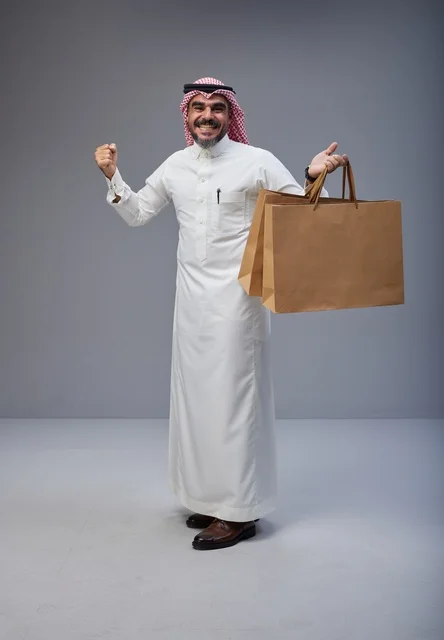 رجل سعودي يحمل أكياس تسوق في استوديو احترافي