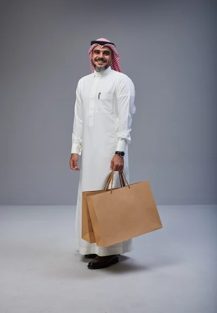 Saudi Man Holding Shopping Bags in Studio