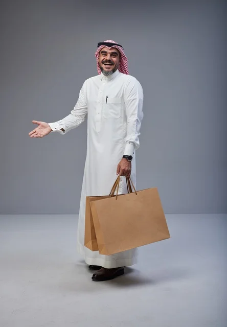 رجل سعودي يحمل أكياس تسوق في استوديو