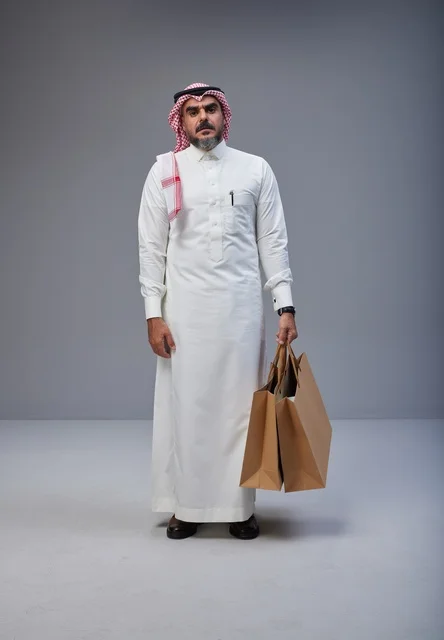 رجل سعودي يحمل أكياس تسوق في الاستوديو