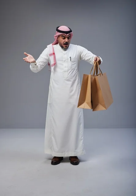 Surprised Saudi Man with Shopping Bags in Studio