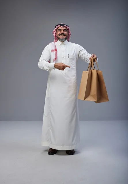Saudi Man Holding Shopping Bags on Grey Background