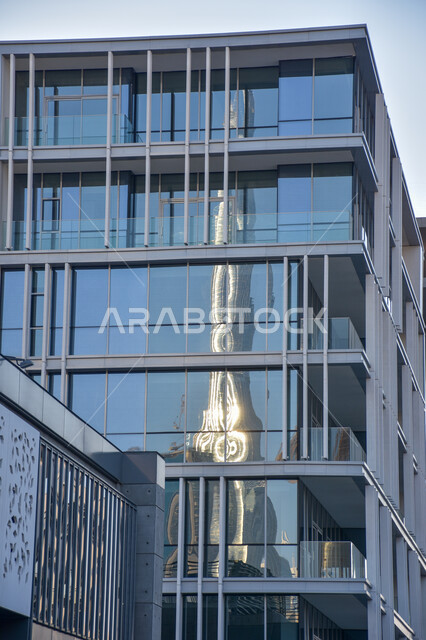 A reflection of the Burj Khalifa in the glass of a skyscraper in Dubai, the famous landmarks of the Emirates, towers and skyscrapers, tourism in the United Arab Emirates.