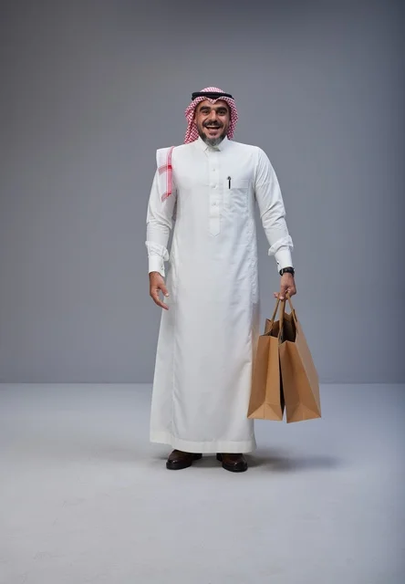 رجل سعودي بالزي التقليدي يحمل أكياس تسوق