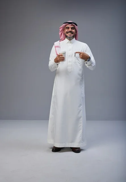 Saudi Man in Traditional Dress Holding Coffee Cup