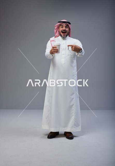 Excited Saudi Man Holding Coffee Cup in Studio Shot