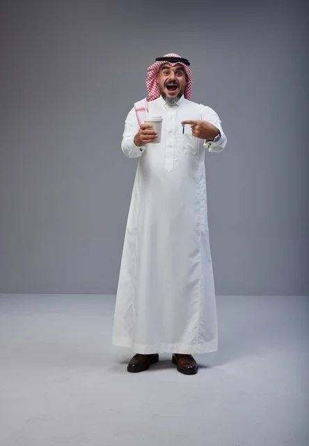 Excited Saudi Man Holding Coffee Cup in Studio Shot