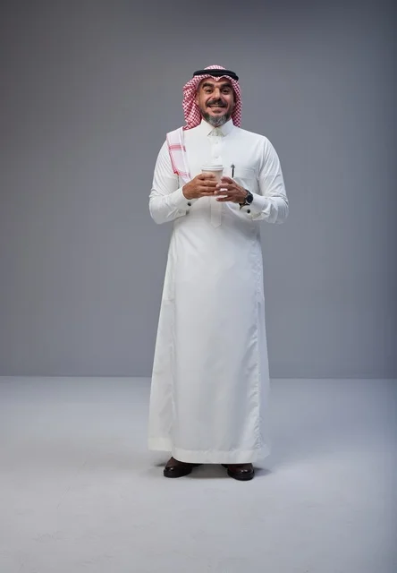 Saudi Man in Traditional Thobe Holding Glass of Water